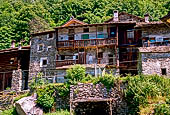 Val Bregaglia - Savogno. Le caratteristiche abitazioni in pietra, alte con lunghi e stretti loggiati in legno che coprono l'intera facciata.